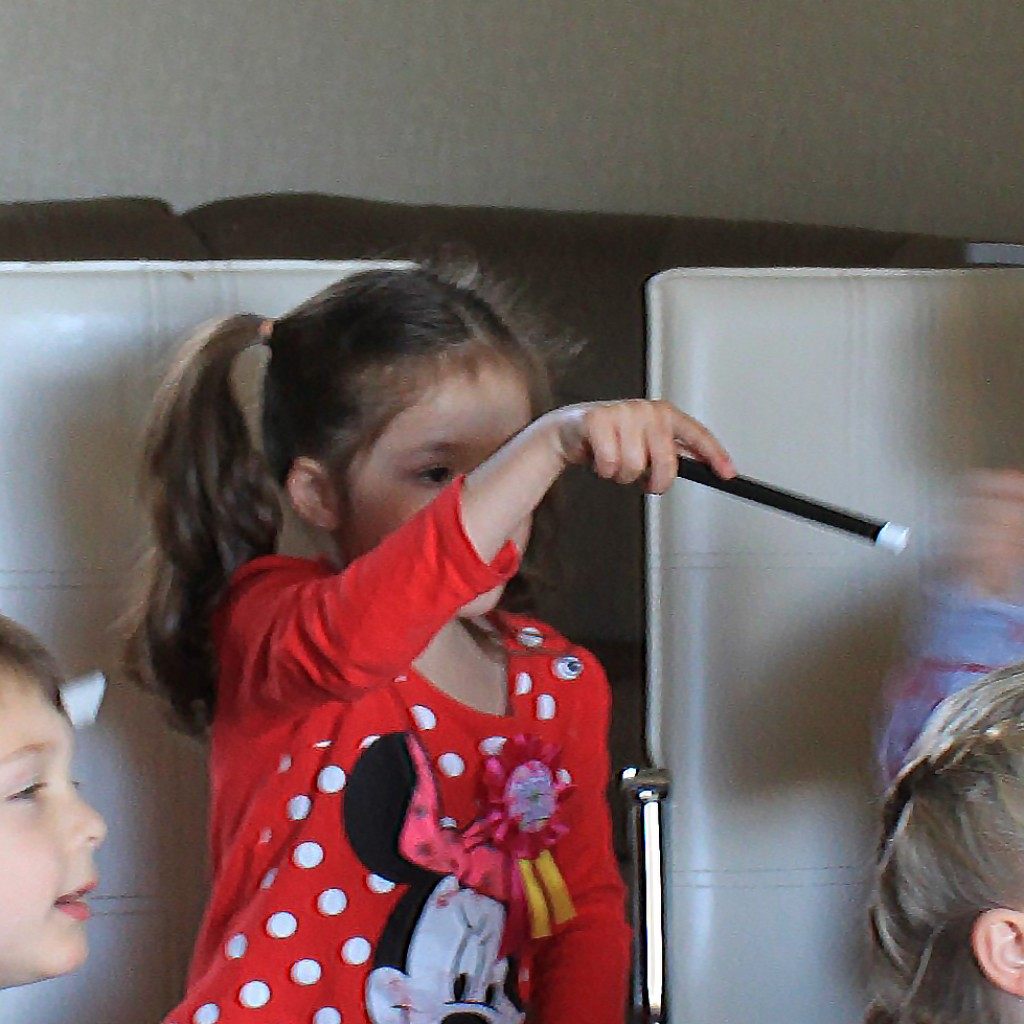 A child participating in a magic show with a wand