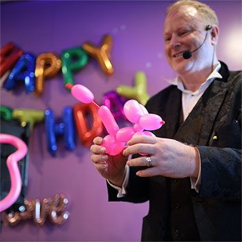 Jimmy Marvel twisting a pink poodle balloon